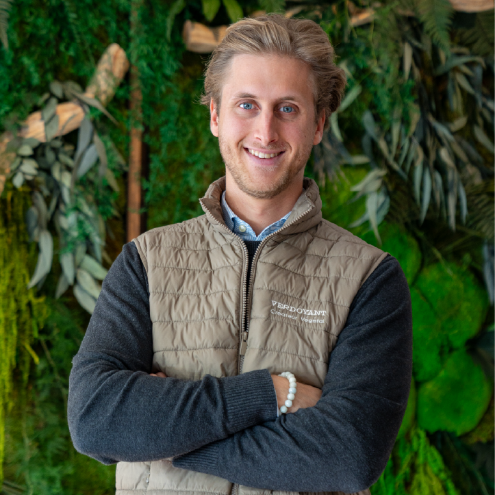 Hugo majewski, fondateur Verdoyant Homme souriant, les bras croisés, devant un mur végétal stabilisé.